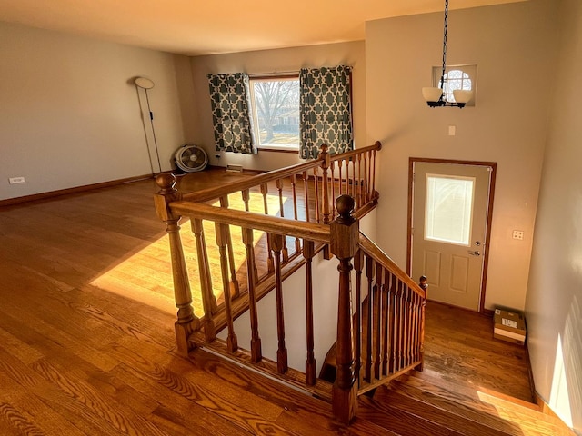 stairway featuring a notable chandelier and hardwood / wood-style flooring