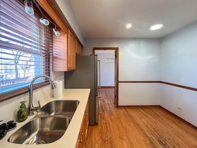 kitchen featuring sink, stainless steel fridge, and light hardwood / wood-style floors