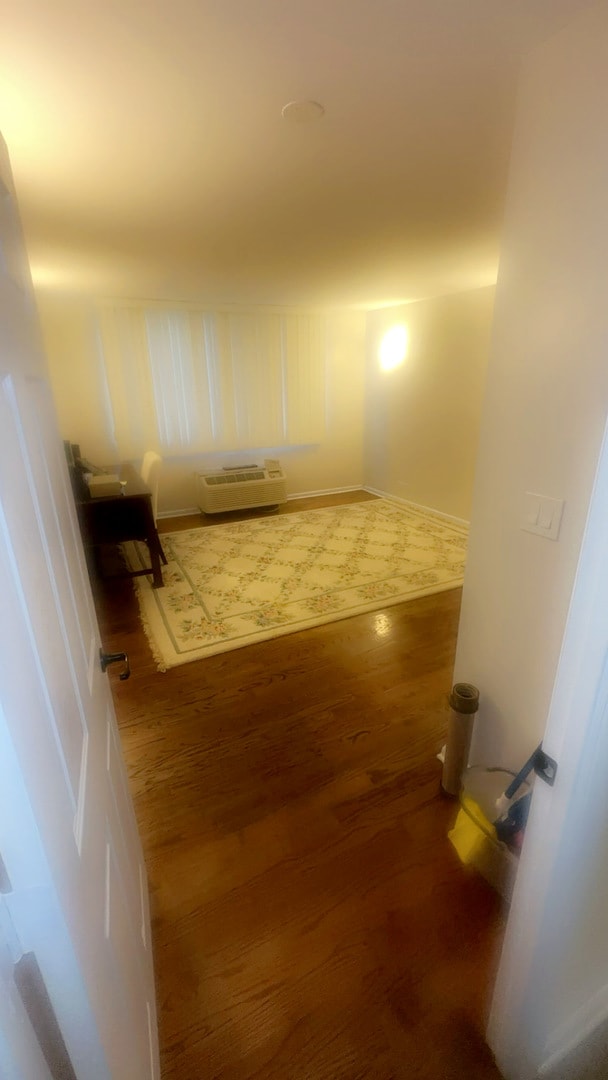 hallway featuring dark hardwood / wood-style floors and a wall mounted AC