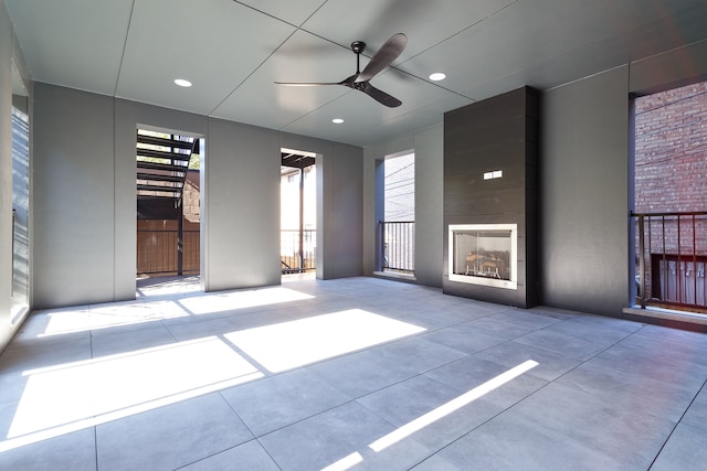 unfurnished living room with a fireplace and ceiling fan