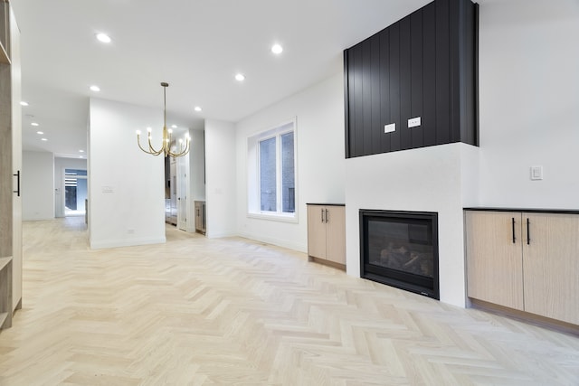 unfurnished living room featuring an inviting chandelier and light parquet floors