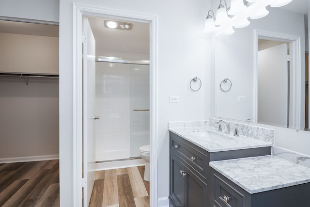 bathroom featuring vanity, a shower with shower door, toilet, and hardwood / wood-style flooring