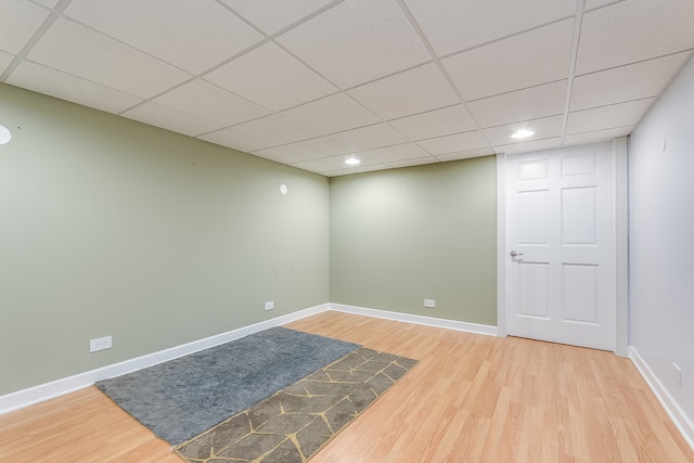 spare room with a drop ceiling and hardwood / wood-style floors