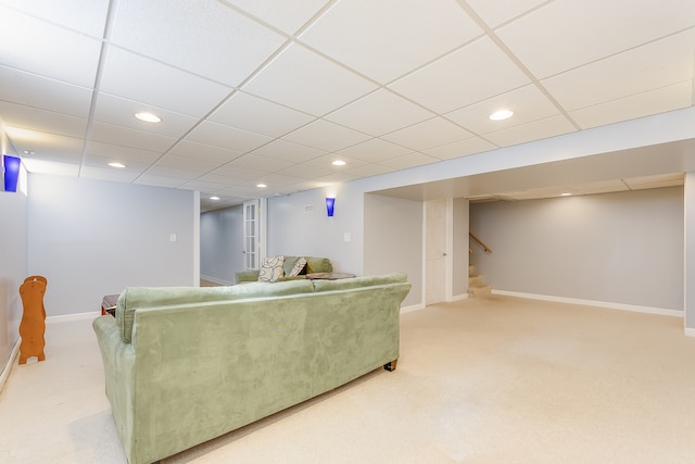 living room featuring light carpet and a paneled ceiling