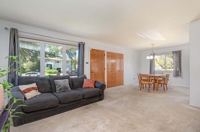 carpeted living room with a chandelier