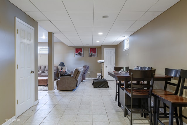 tiled dining space with a paneled ceiling and plenty of natural light