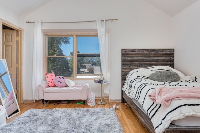 bedroom featuring hardwood / wood-style flooring and lofted ceiling