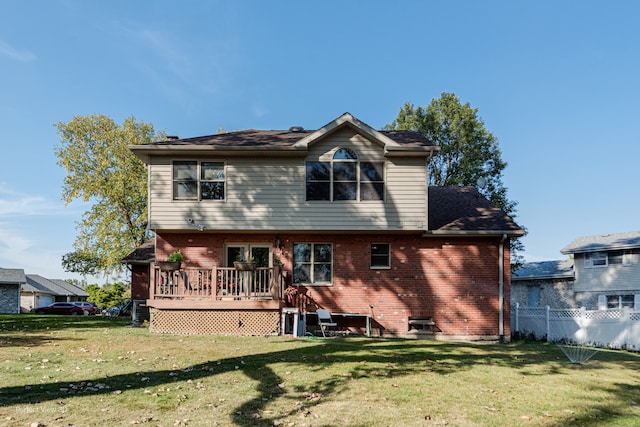 back of house with a wooden deck and a lawn