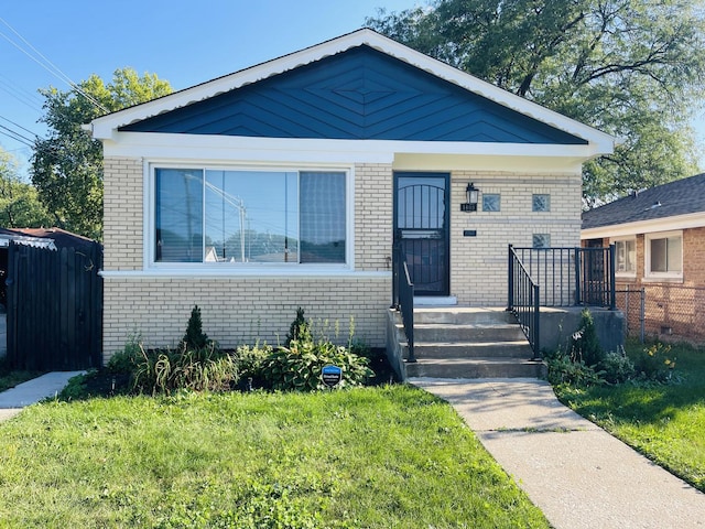 1409 E 90th St, Chicago, IL 60619 - bungalow with brick siding, a front yard, and fence