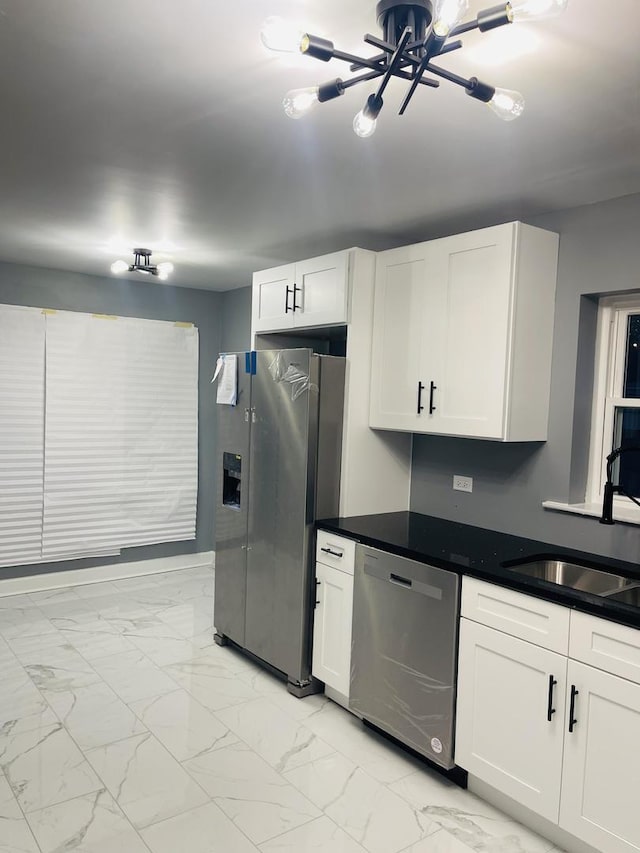 kitchen with sink, a chandelier, stainless steel appliances, and white cabinets