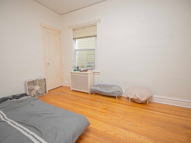 bedroom featuring ornamental molding and wood-type flooring