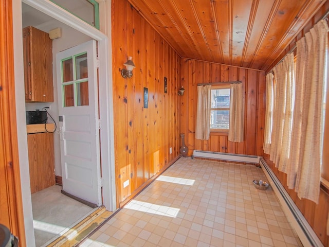 unfurnished room featuring wooden walls, wood ceiling, a baseboard heating unit, and lofted ceiling