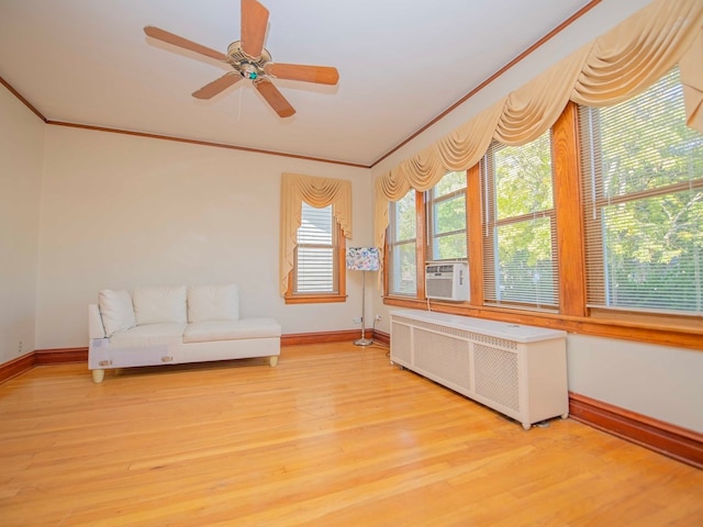 interior space with ceiling fan, light hardwood / wood-style floors, ornamental molding, and radiator