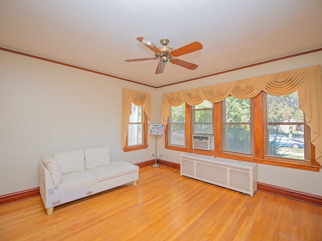 unfurnished room featuring ornamental molding, ceiling fan, radiator heating unit, and light hardwood / wood-style floors