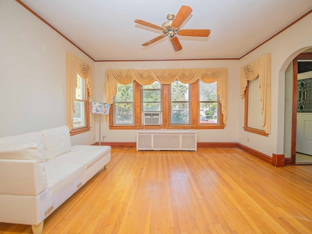 unfurnished room featuring light wood-type flooring, ceiling fan, radiator heating unit, crown molding, and cooling unit