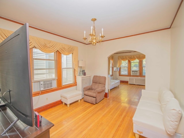 living room featuring a chandelier, wood-type flooring, radiator heating unit, crown molding, and cooling unit