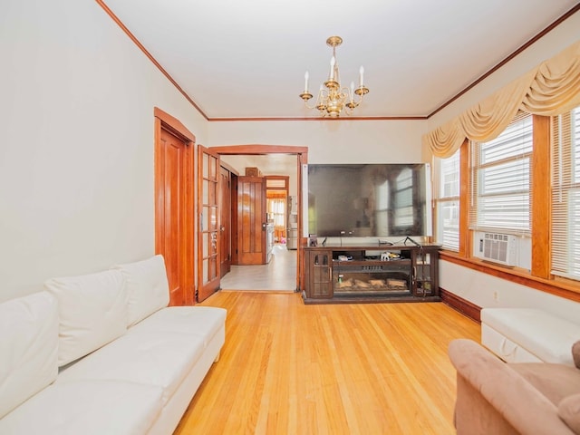 living room with cooling unit, hardwood / wood-style flooring, crown molding, and a notable chandelier