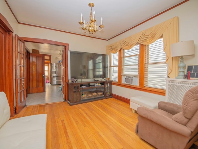 living room featuring an inviting chandelier, cooling unit, crown molding, and hardwood / wood-style flooring