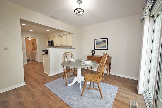 dining space with washer and clothes dryer and light hardwood / wood-style floors