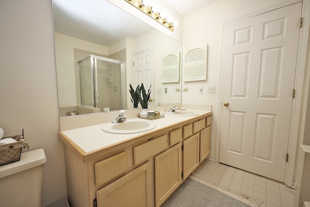 bathroom featuring an enclosed shower, vanity, tile patterned flooring, and toilet