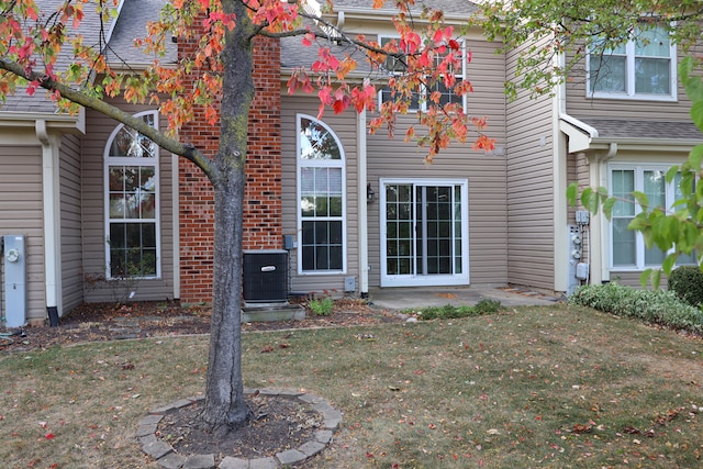 exterior space featuring cooling unit and a lawn