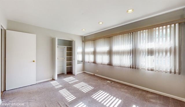 unfurnished bedroom with a closet and light carpet