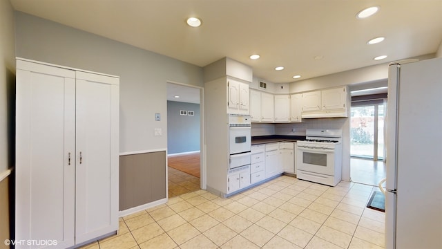 kitchen featuring light tile patterned floors, white appliances, and white cabinetry