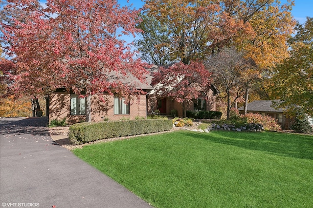 view of property hidden behind natural elements with a front yard