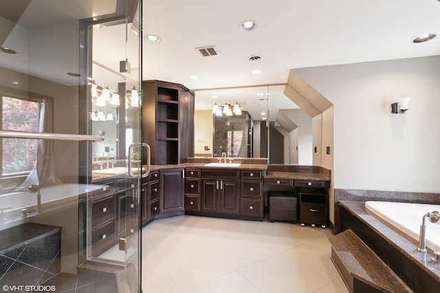 bathroom with vanity, tiled bath, and tile patterned flooring