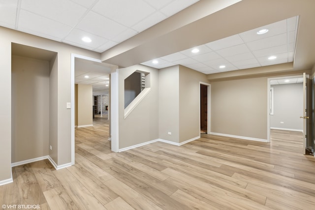 basement featuring light hardwood / wood-style flooring and a drop ceiling