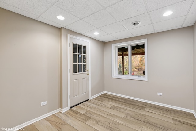 unfurnished room with light hardwood / wood-style floors and a drop ceiling