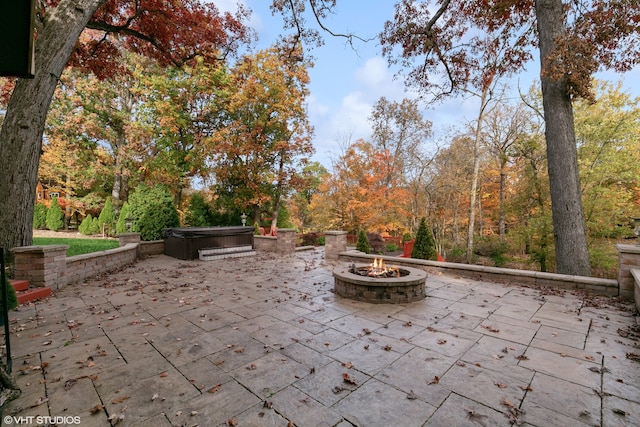 view of patio with a hot tub and a fire pit