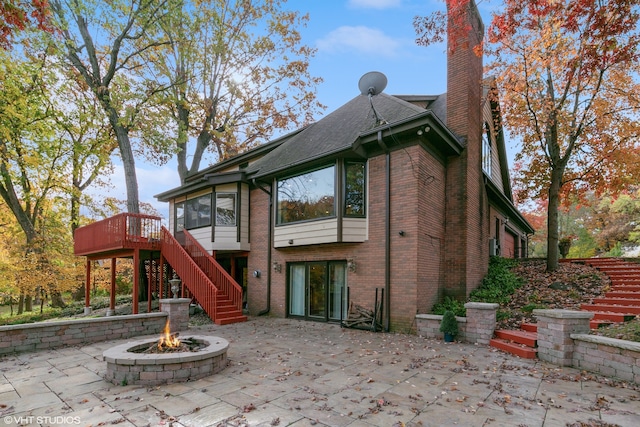 rear view of house with a patio area, a deck, and a fire pit