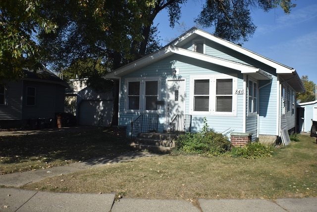 bungalow-style home with a front lawn