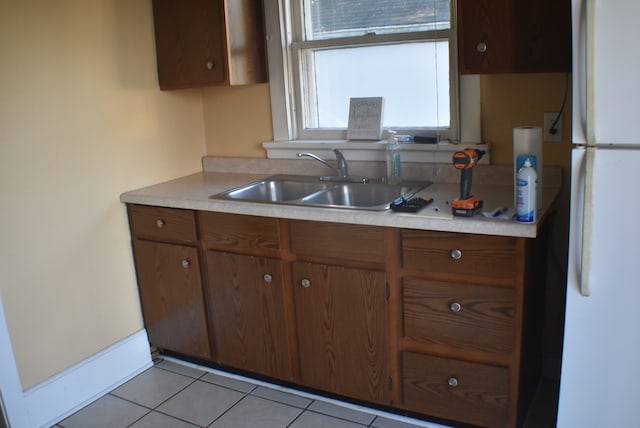 kitchen with sink, white fridge, and light tile patterned flooring