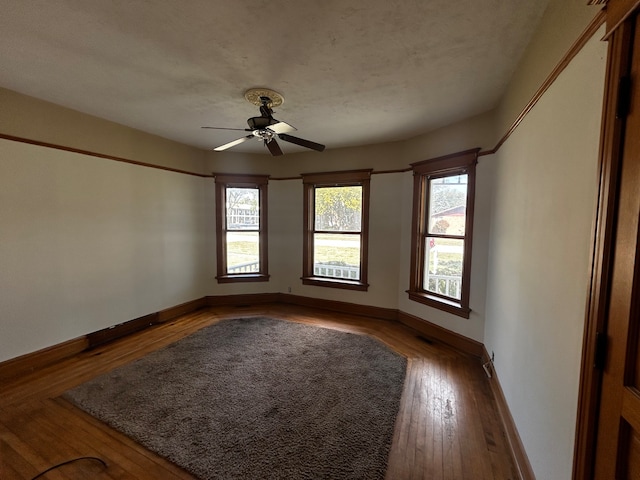 unfurnished room featuring ceiling fan, hardwood / wood-style flooring, and a textured ceiling