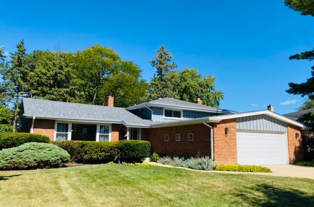 view of front of house with an attached garage, driveway, a chimney, and a front yard