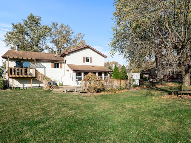 rear view of property with a yard and a deck