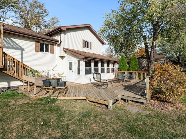 rear view of house featuring a deck and a lawn