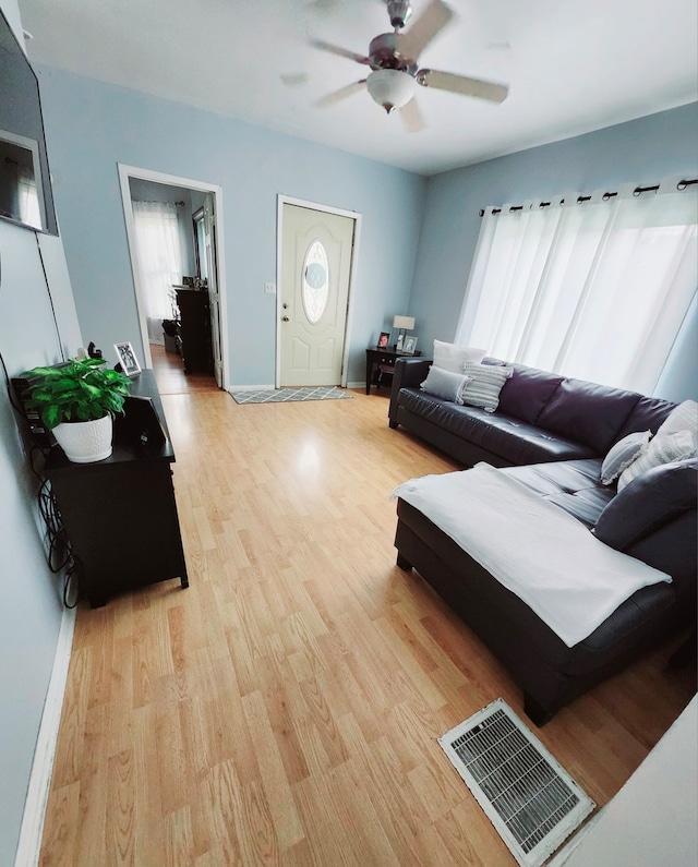 living room with ceiling fan and light wood-type flooring