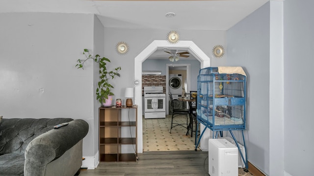 dining room featuring dark hardwood / wood-style flooring, stacked washer / dryer, and ceiling fan