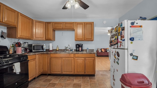 kitchen with gas stove, ceiling fan, sink, white refrigerator, and light hardwood / wood-style floors