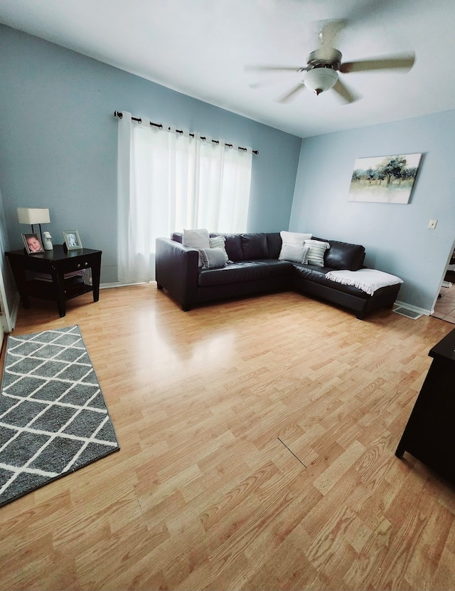 living room featuring light hardwood / wood-style floors and ceiling fan