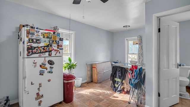 interior space with white fridge and ceiling fan