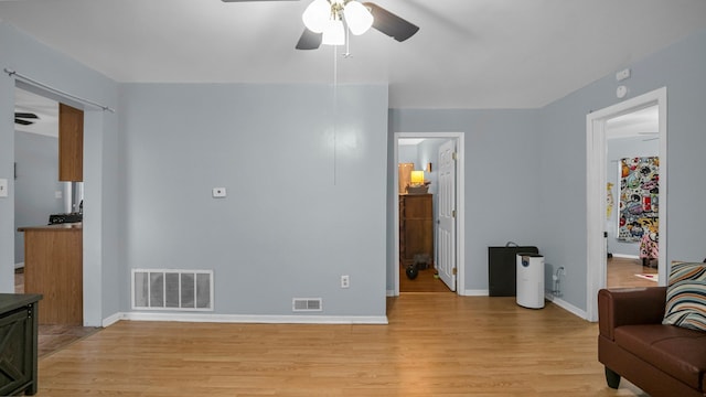 living room with light wood-type flooring and ceiling fan