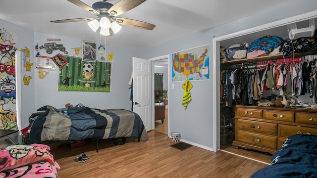 bedroom with ceiling fan, wood-type flooring, and a closet