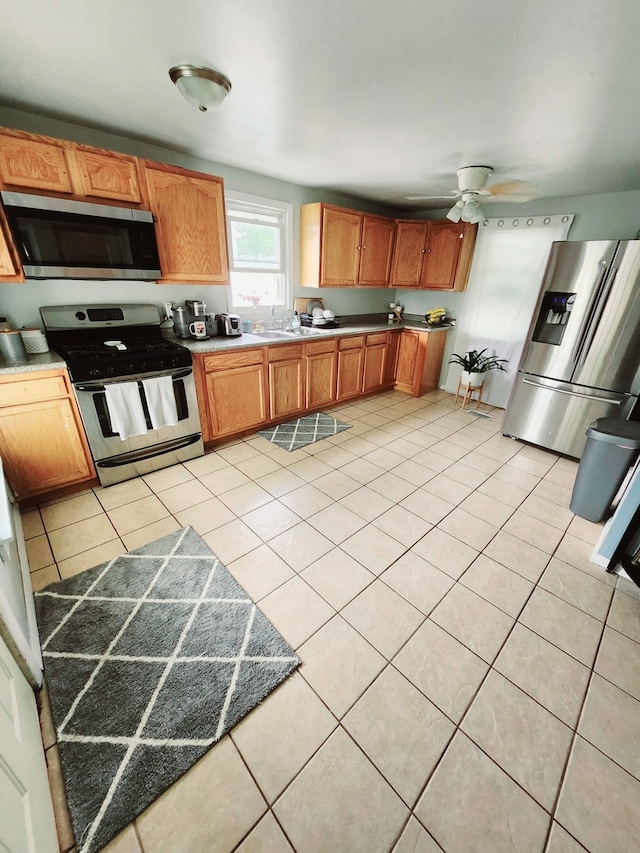 kitchen featuring ceiling fan, sink, light tile patterned floors, and appliances with stainless steel finishes