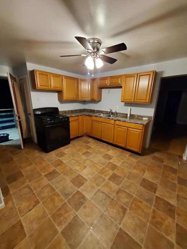 kitchen featuring black gas stove, ceiling fan, and sink