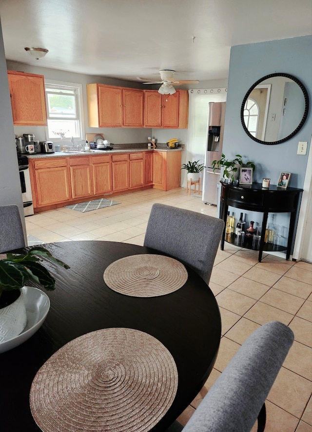 tiled dining area featuring ceiling fan and sink