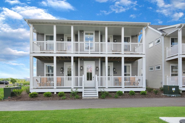 coastal home with a balcony, a porch, and central AC